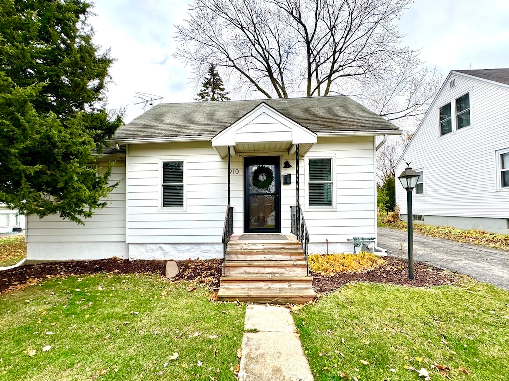 bungalow-style house featuring a front lawn