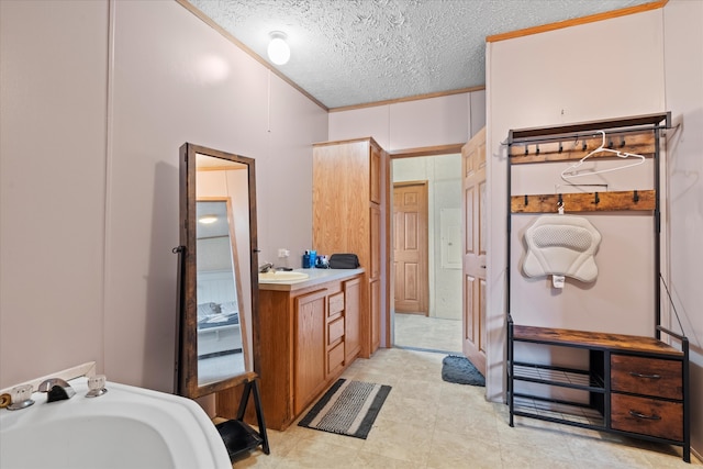 bathroom featuring vanity, a textured ceiling, and ornamental molding