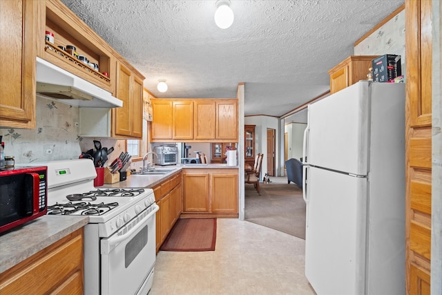 kitchen with sink, white appliances, a textured ceiling, and range hood