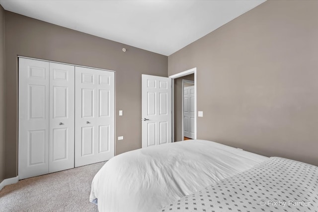 bedroom featuring light colored carpet and a closet