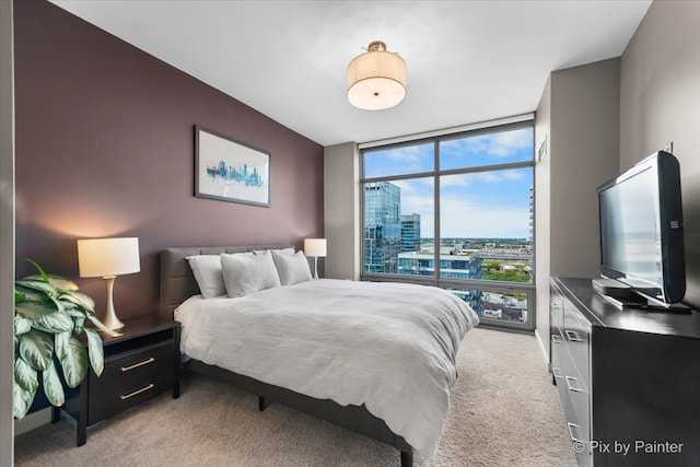 carpeted bedroom featuring a wall of windows