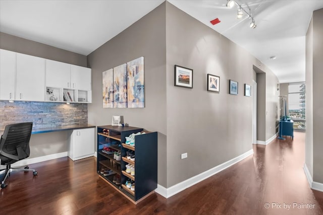 interior space with tasteful backsplash, dark hardwood / wood-style flooring, white cabinets, and track lighting