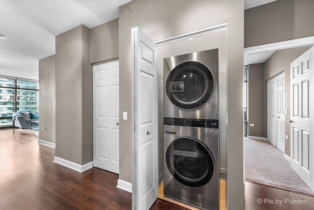 washroom with dark hardwood / wood-style floors and stacked washing maching and dryer