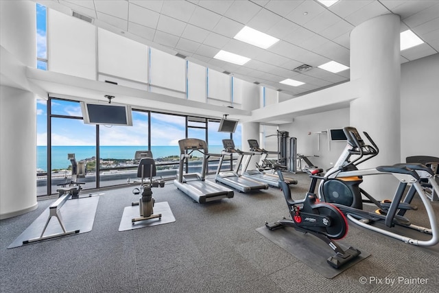 gym with a paneled ceiling and a high ceiling