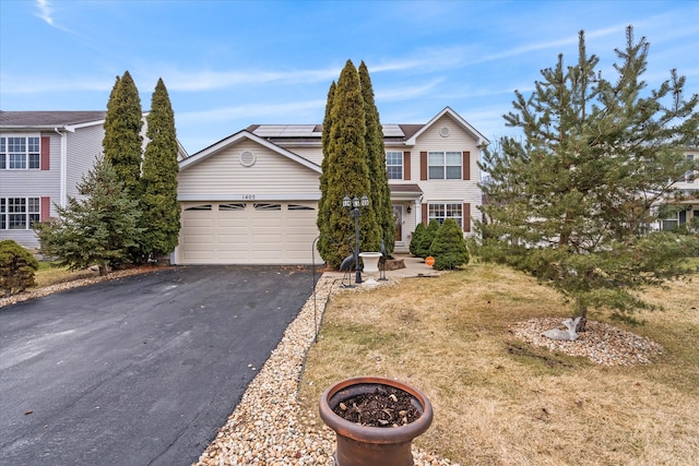 view of front of house featuring solar panels, a garage, and a front yard