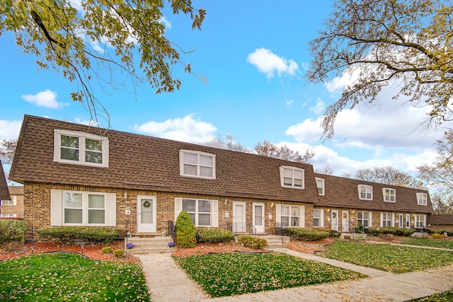 townhome / multi-family property featuring a front lawn