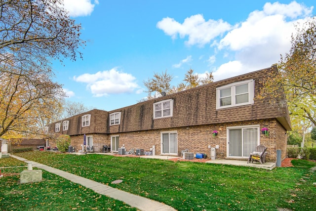 back of house with central AC unit, a lawn, and a patio