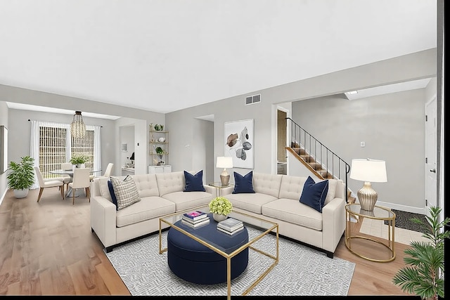 living room with a chandelier and light hardwood / wood-style floors