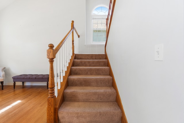 stairs featuring wood finished floors and baseboards