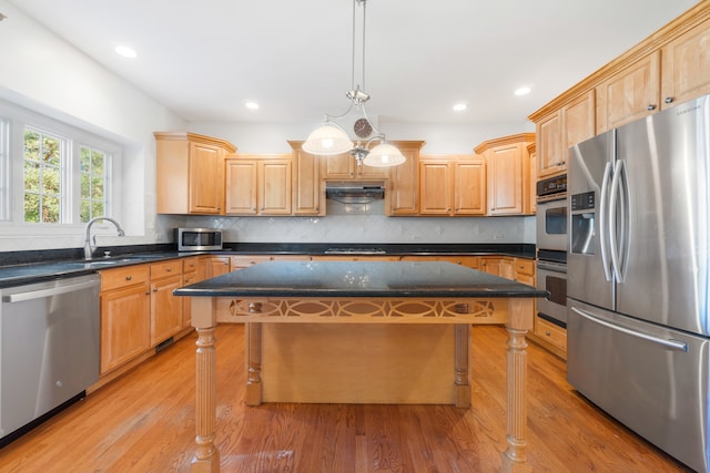 kitchen featuring pendant lighting, a center island, a kitchen breakfast bar, appliances with stainless steel finishes, and light hardwood / wood-style floors