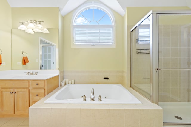 bathroom with a stall shower, vaulted ceiling, vanity, a bath, and tile patterned floors