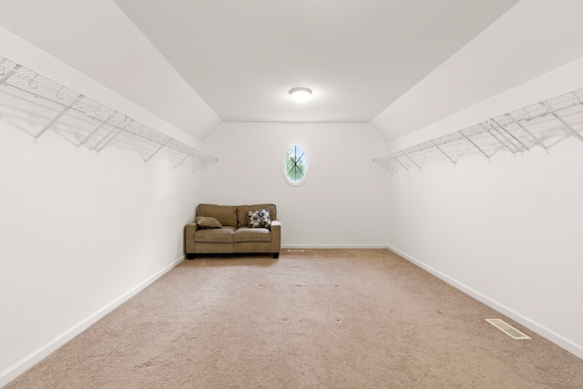 walk in closet with vaulted ceiling and carpet