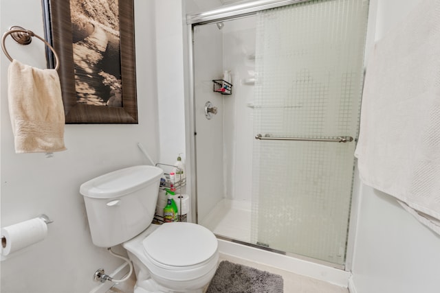 bathroom with a shower with shower door and toilet