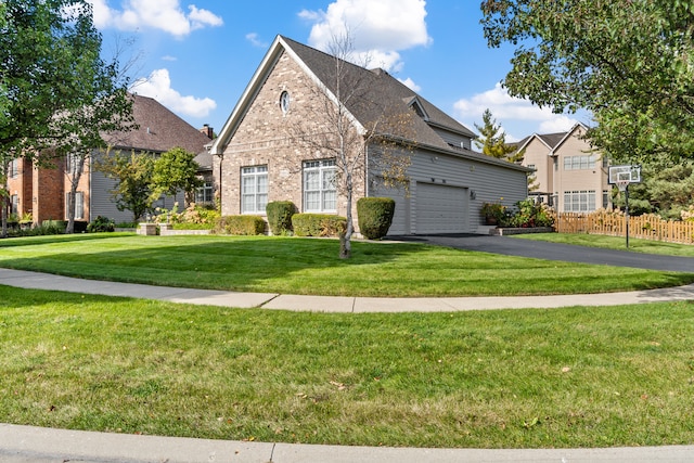 view of front of house featuring aphalt driveway, a front yard, brick siding, and fence