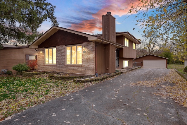 property exterior at dusk featuring an outbuilding and a garage