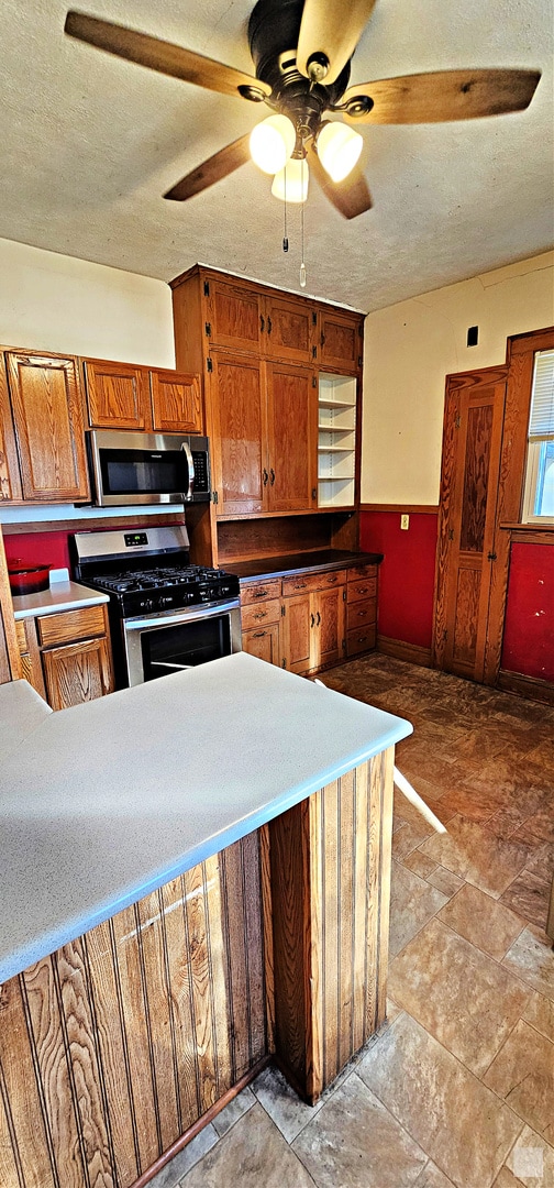 kitchen featuring a textured ceiling, stainless steel appliances, and ceiling fan