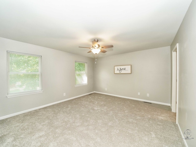 carpeted spare room featuring ceiling fan