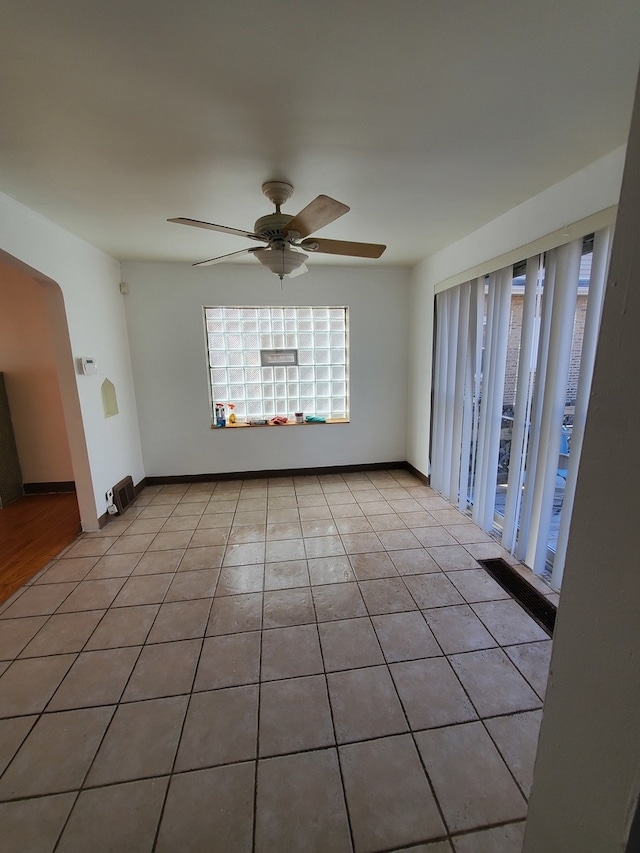 tiled spare room with ceiling fan