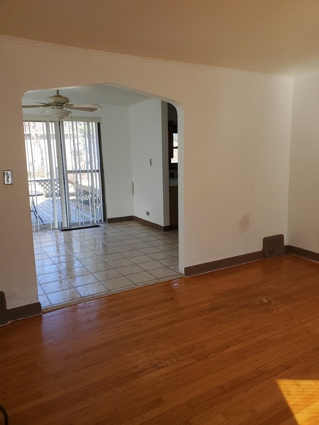 unfurnished room featuring ceiling fan, ornamental molding, and light wood-type flooring