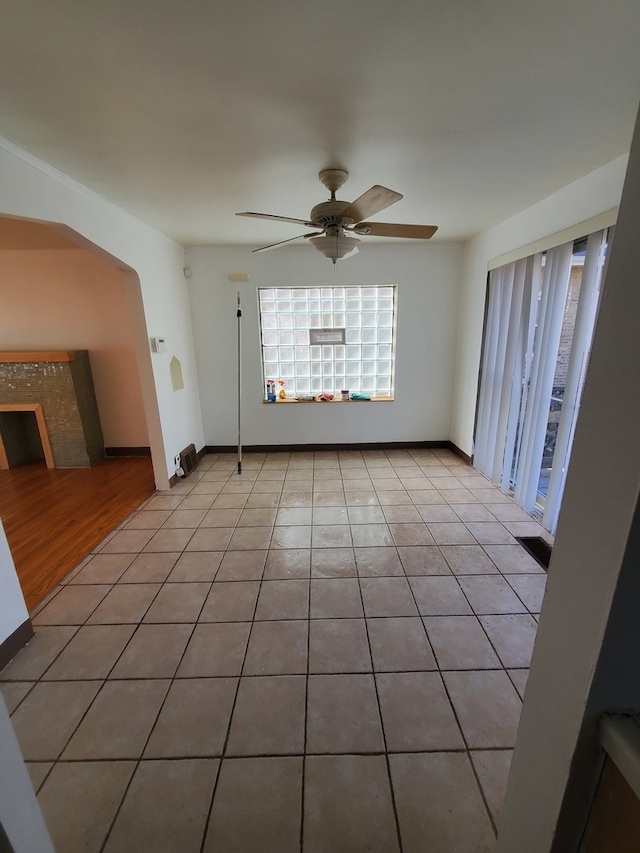 unfurnished living room featuring ceiling fan and light tile patterned flooring