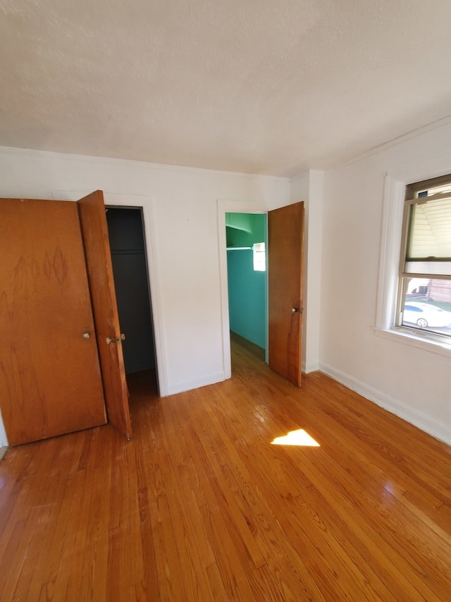 unfurnished bedroom with light hardwood / wood-style floors and a closet