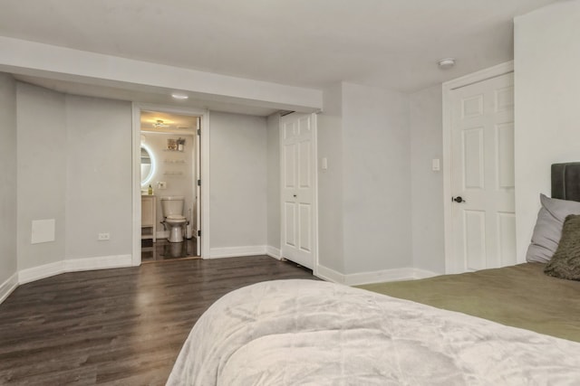 bedroom with dark wood-type flooring and ensuite bath