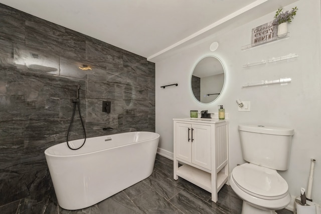 bathroom with a washtub, vanity, toilet, and tile walls