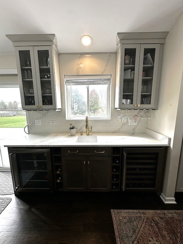 bar with wine cooler, a wealth of natural light, dark hardwood / wood-style flooring, and sink