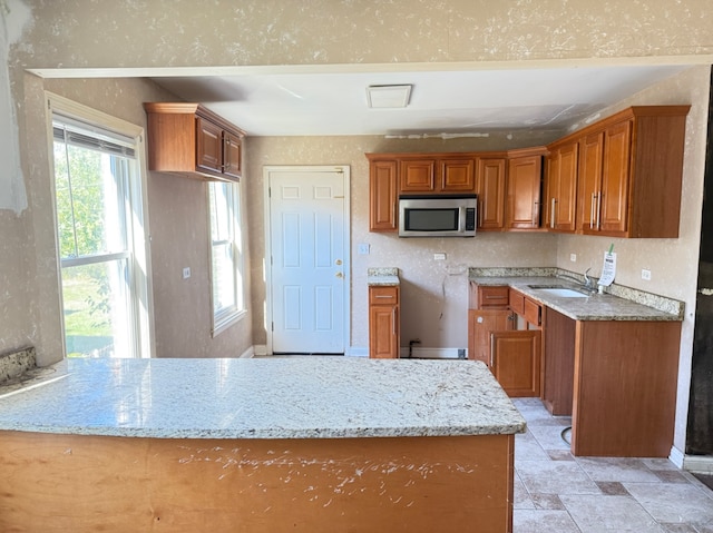 kitchen featuring light stone counters and sink