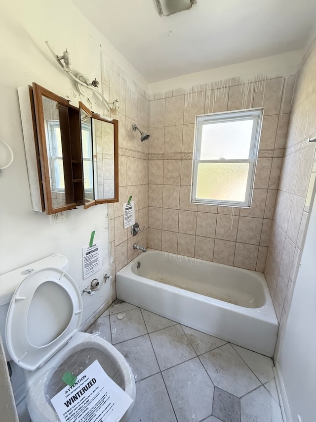 bathroom featuring tile patterned flooring and tiled shower / bath