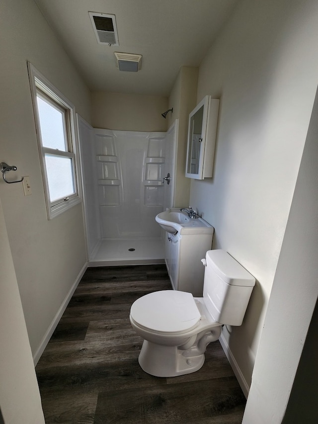 bathroom featuring vanity, hardwood / wood-style flooring, toilet, and walk in shower