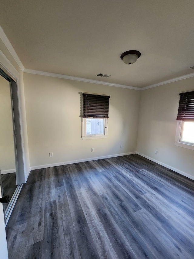 empty room featuring dark hardwood / wood-style floors and crown molding