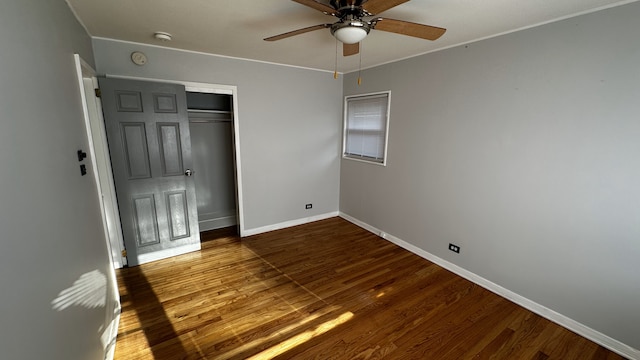 unfurnished bedroom featuring ceiling fan, a closet, and dark wood-type flooring