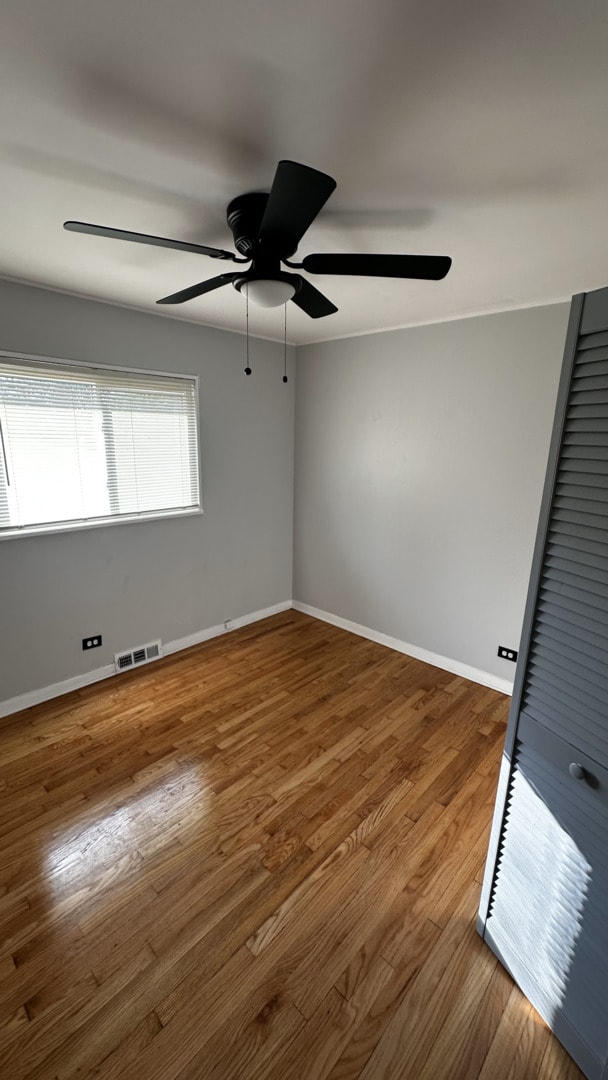 spare room with hardwood / wood-style floors and ceiling fan