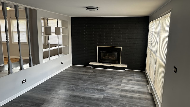 interior space with dark hardwood / wood-style floors and brick wall