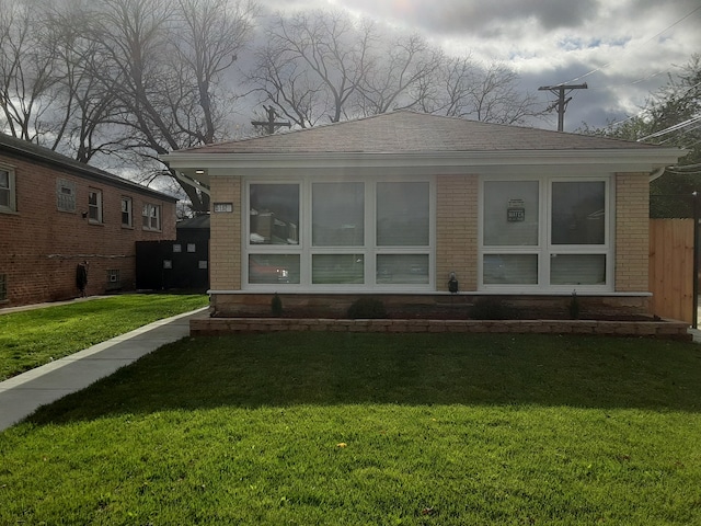 rear view of property with a sunroom and a yard