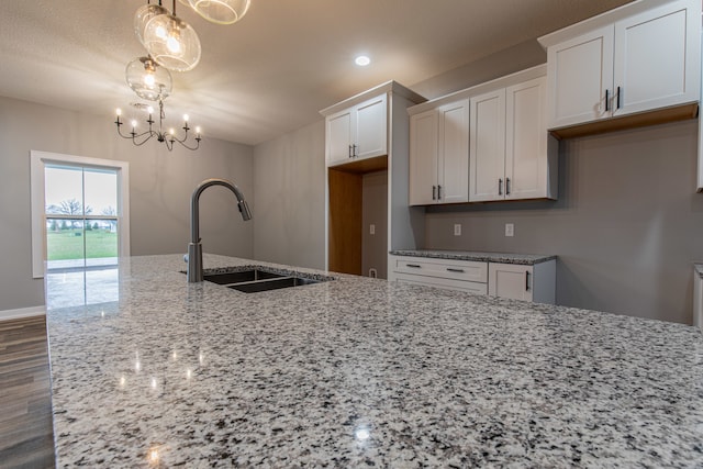 kitchen featuring white cabinets, pendant lighting, and sink