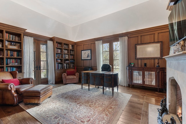 office space featuring wood walls, french doors, and wood-type flooring