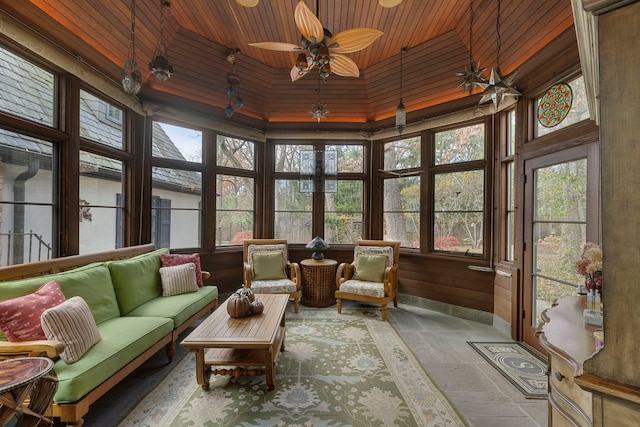 sunroom / solarium featuring ceiling fan, a wealth of natural light, and wood ceiling