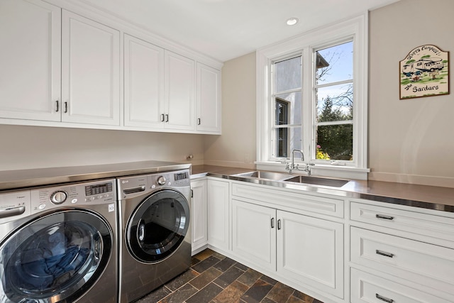 washroom featuring washer and dryer, cabinets, and sink