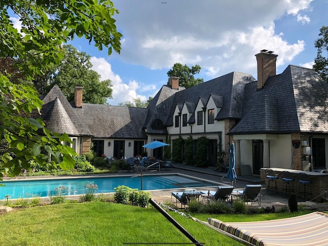 view of pool featuring a lawn and a patio