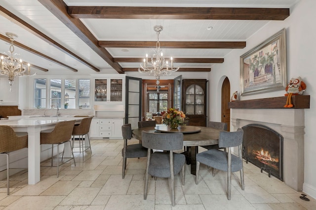 dining space with beam ceiling and an inviting chandelier