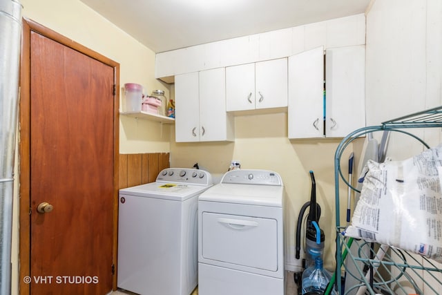 clothes washing area featuring cabinets and separate washer and dryer