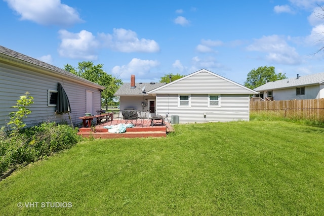 rear view of property with central AC, a deck, and a lawn