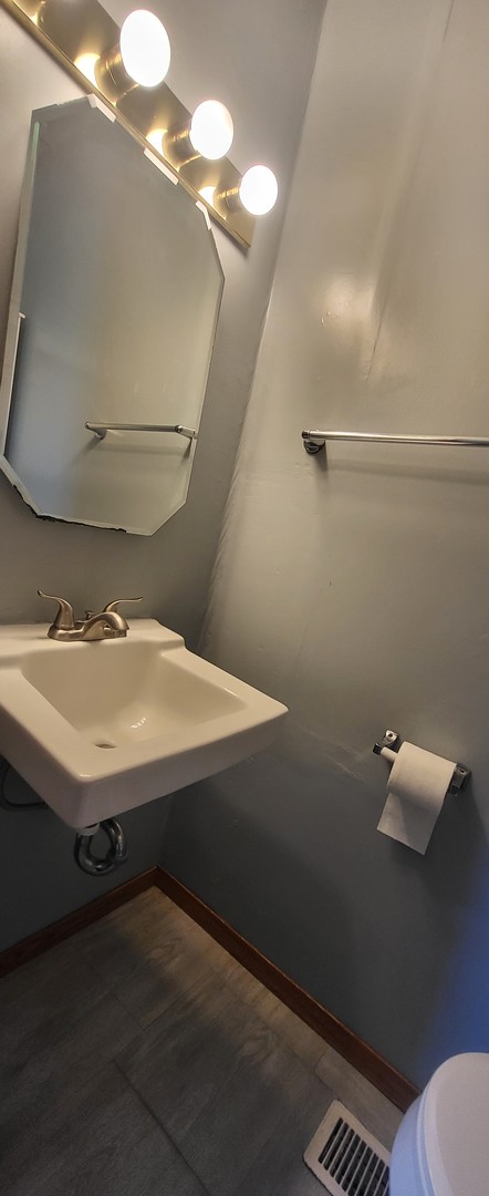 bathroom featuring toilet, hardwood / wood-style floors, and sink