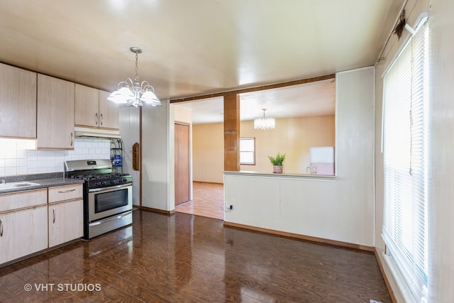 kitchen featuring decorative backsplash, stainless steel gas stove, hanging light fixtures, and a notable chandelier