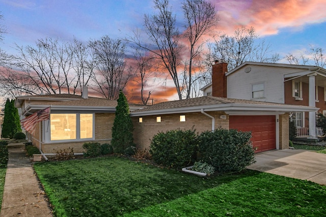 view of front of property featuring a garage and a lawn