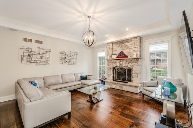 living room with a fireplace, crown molding, dark hardwood / wood-style flooring, and a notable chandelier