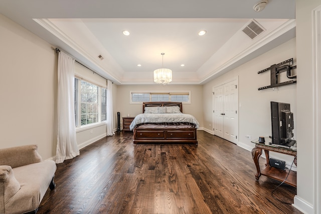 bedroom featuring a tray ceiling, dark wood-type flooring, a notable chandelier, and ornamental molding