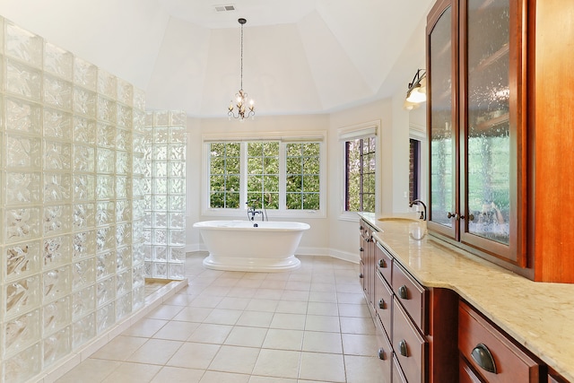 bathroom featuring a tub to relax in, tile patterned floors, a chandelier, vaulted ceiling, and vanity